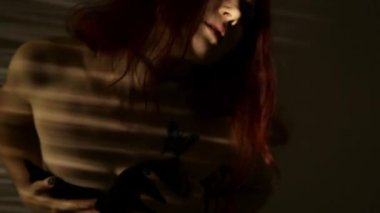 dans ve çizgili bir gölge göğüslerini okşayarak Kızıl saçlı kadın. tutku ve seks oyunları kavramı