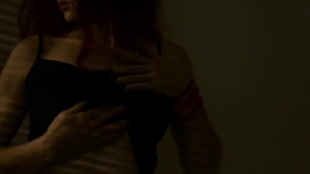 Rossa donna che balla e accarezza il seno su un'ombra a strisce. passione e sesso giochi concetto — Video Stock