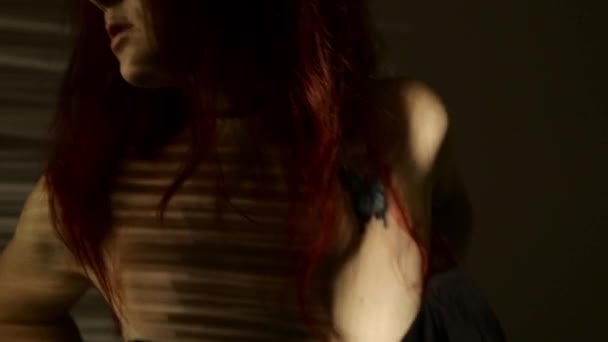 Рыжая женщина танцует и гладит свою грудь по полосатой тени. страсть и сексуальные игры — стоковое видео