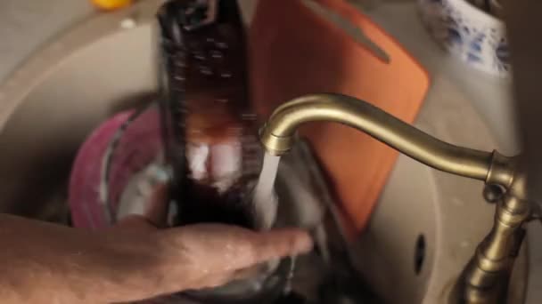 Чоловік миє посуд, крупним планом руки і губку — стокове відео
