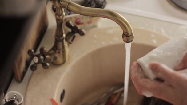 Adam bir bulaşıkları yıkar, köpük ve deterjan plakaları durulama — Stok video