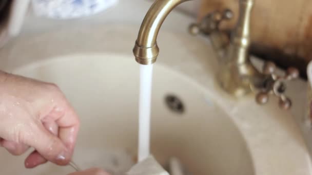 Mani close-up mans lava i piatti, getto d'acqua risciacqua i piatti da schiuma e detergente — Video Stock