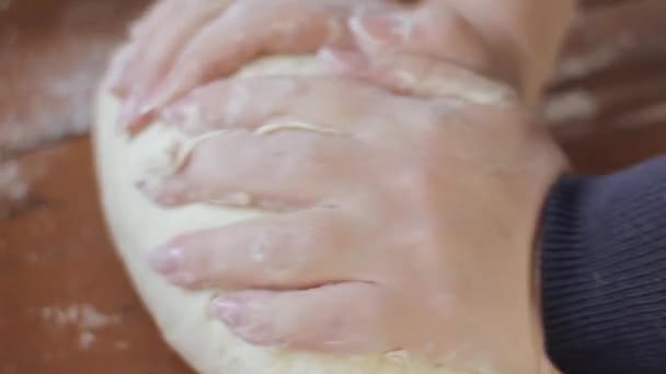 mains de femme pétrissant la pâte sur la table. cuisson des aliments sur une cuisine 