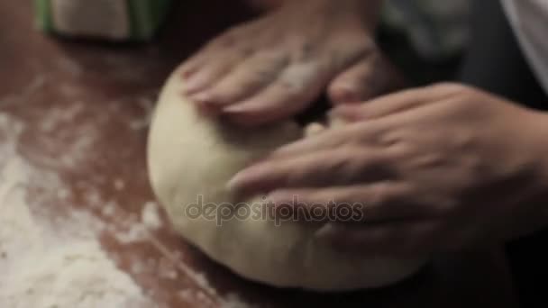 Женские руки разминают тесто на столе. приготовление пищи на кухне — стоковое видео
