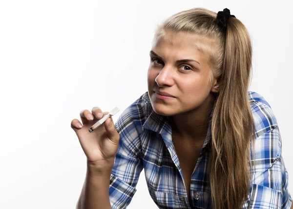 Jovem mulher bonita em camisa quadriculada fumar maconha em um fundo branco . — Fotografia de Stock