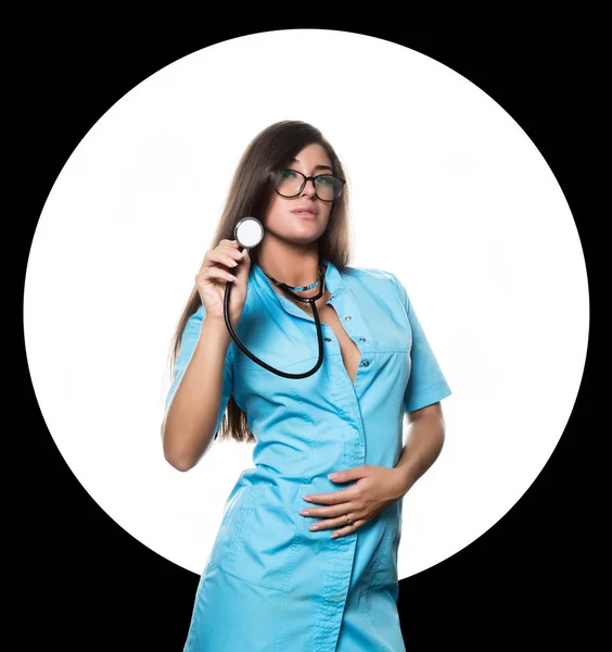 Sexy doctora con estetoscopio sobre un círculo blanco y fondo negro —  Fotos de Stock