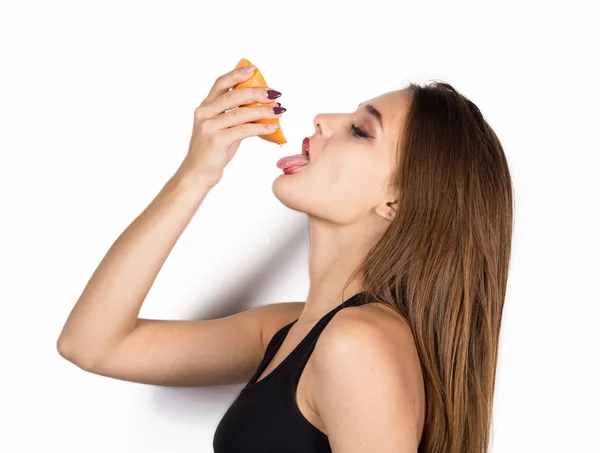 Młoda kobieta zmysłowy z grapefruitem w jej ręce, dziewczyna jest spożywanie grejpfrutów — Zdjęcie stockowe