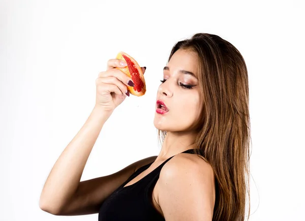 Joven mujer sensual con pomelo en las manos, chica está comiendo pomelo —  Fotos de Stock