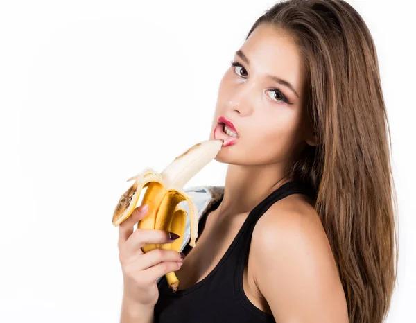 Mujer sensual joven comiendo plátano sobre fondo blanco. concepto de provocación — Foto de Stock