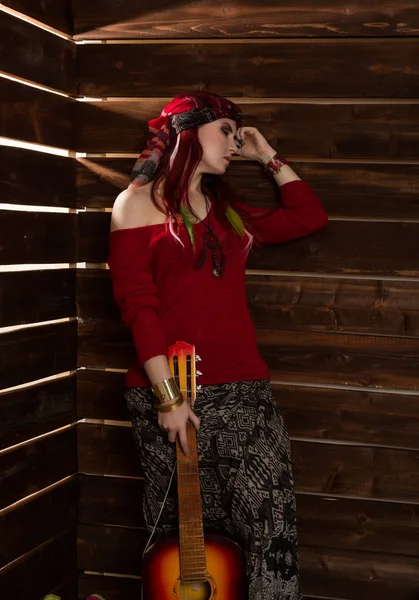 Alegre hippie boho ruiva mulher de pé com guitarra em um fundo de parede de madeira — Fotografia de Stock