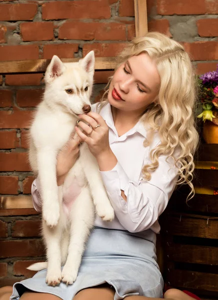 Счастливая блондинка с щенком хаски на осеннем фоне — стоковое фото