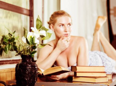 genç kadın bir Resepsiyon bir pencerenin önünde yatan bir kitap okur. eski stil, lolita kavramı