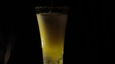 Bira bir siyah arka plan üzerine bir bardak içine dökme