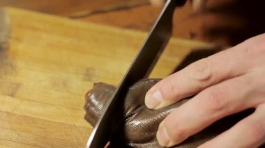 Bir ahşap tahta üzerinde füme balık kesmek