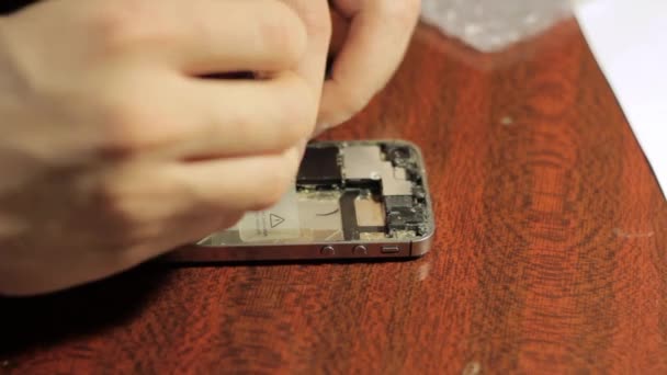 Electronics repair. Master repairs cell phone. The internal components of a smartphone — Stock Video