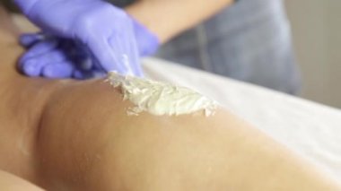 Bacaklar Epilasyonun şeker ile kitle. İş yerinde shugaring ustası