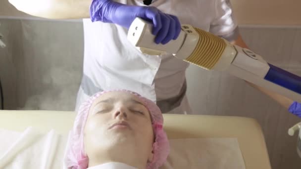 Mooi vrouwen gezicht met gesloten ogen wordt gereinigd met stoom therapie in schoonheid Wellness — Stockvideo