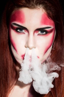 Profesyonel makyaj güzel seksi şeytan kız. Moda sanat tasarımı. Çekici kadın darbeler duman burun