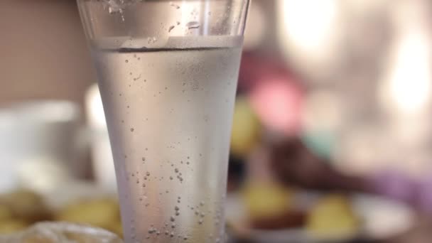 Стакан с минеральной водой на столе, сельский завтрак из печеного картофеля и сосисок — стоковое видео