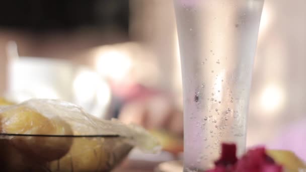 El vaso con el agua mineral sobre la mesa, el desayuno rural de la patata cocida y las salchichas — Vídeos de Stock