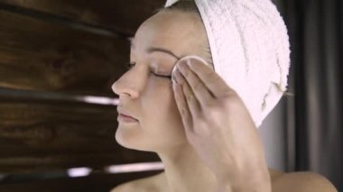 Bir havlu güzel kadın aynanın önünde makyaj kapalı alır. Evde Spa