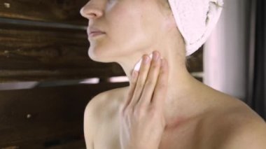 Bir havlu güzel kadın aynanın önünde makyaj kapalı alır. Evde Spa