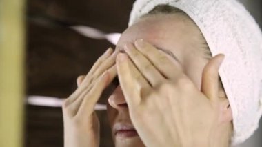 Nemlendirici krem yüzüne koydu bir havlu güzel sağlıklı kadın. Cilt Bakımı ve ev Spa