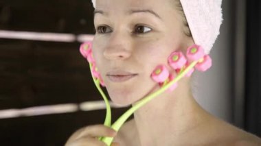 güzel kadın kozmetik prosedürler içinde ev işi havlu. yüz masaj masaj aleti ile