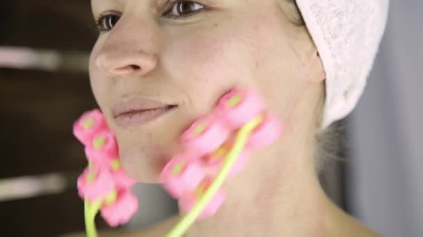 Hermosa mujer en toalla haciendo procedimientos cosméticos en casa. masaje facial con masajeador — Vídeo de stock