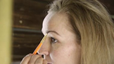 Havlu, güzel kadın aynanın önünde kaşlarını boyalar