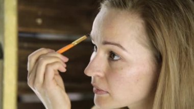 Havlu, güzel kadın aynanın önünde kaşlarını boyalar