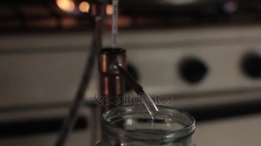 Ev üretim alkol alev yanıyor. Alkol damıtma donanımları, cam kavanoza hooch sıvı akış