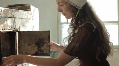 içinde bir rustik harap bir terk edilmiş evde eski Ocağın yanında oturan kadın