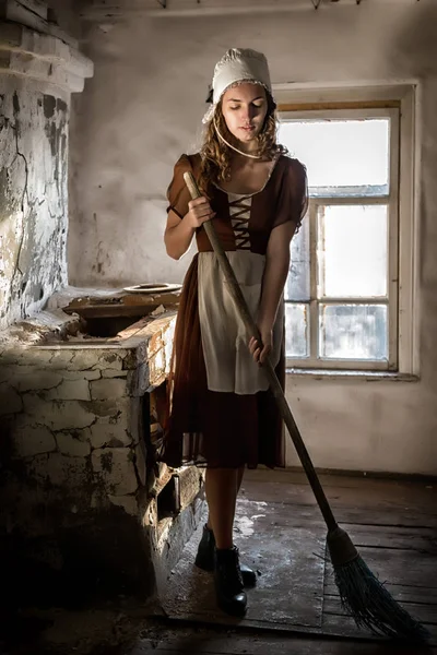 Жінка в сільській сукні замінює дерев'яну підлогу на кухні — стокове фото