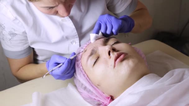 Ahli kecantikan meremas jerawat blackheads untuk wonan muda di salon kecantikan. perawatan kulit wajah — Stok Video