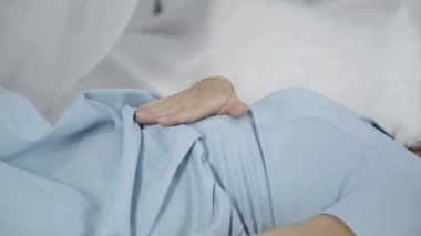 Yalnız genç çekici kadın kendini yatakta yatıyordu okşayarak mavi elbiseli