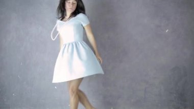 Yalnız genç çekici kadın mavi elbise gülüyor ve dansları