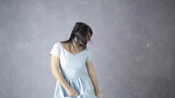Ensam ung attraktiv kvinna i blå klänning skrattar och dansar — Stockvideo