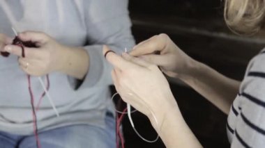 yakın çekim el örgü iğneleri ile yaşlı kadın dokuma kumaşlar ve torunu eğitimi alıyor