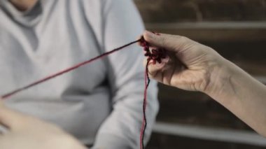 yakın çekim el örgü iğneleri ile yaşlı kadın dokuma kumaşlar ve torunu eğitimi alıyor