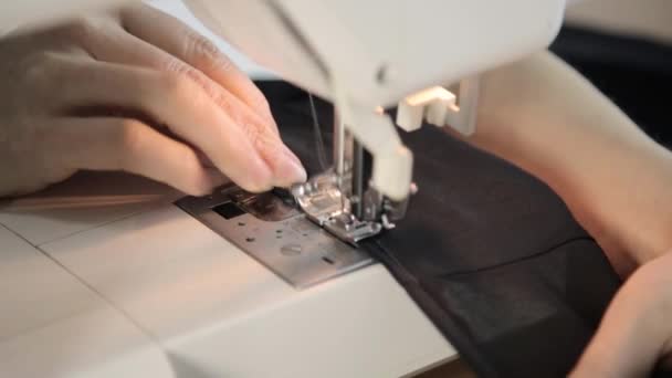 Sewing machine and woman hands, dressmaker supporting a cloth — Stock Video