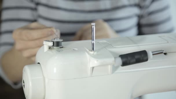 Fil de couturière dans l'aiguille de la machine à coudre, machine à coudre et les mains de la femme — Video