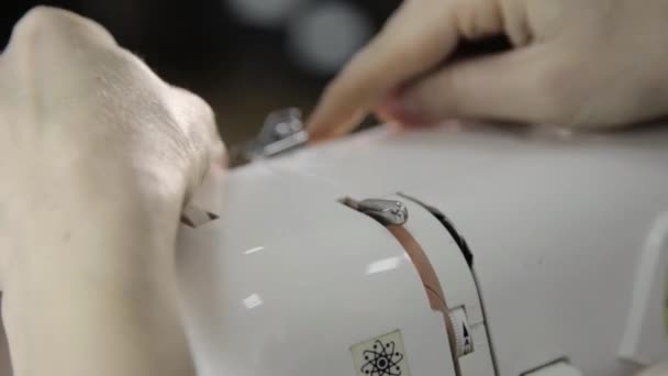 Fil de couturière dans l'aiguille de la machine à coudre, machine à coudre et les mains de la femme — Video