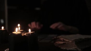 siyah elbiseli, kehanet mum ışığında kartlarındaki mistik güzel kadın