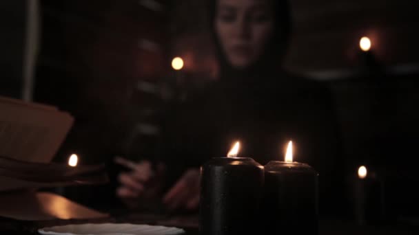 Mystiska vackra kvinnliga fortune teller, röka en cigarett och lägga ut kort med svart candlelight — Stockvideo