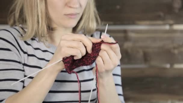뜨개질 바늘로 손을 감고 아름다운 여인은 뜨개질을 한다 — 비디오