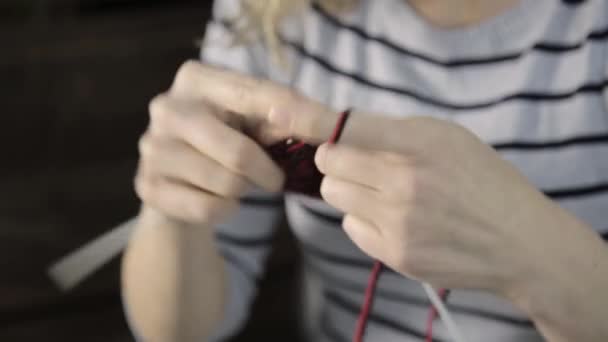 뜨개질 바늘로 손을 감고 아름다운 여인은 뜨개질을 한다 — 비디오