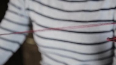 Örgü iğneleriyle yakın çekim eller, güzel bir kadın örgü örer.