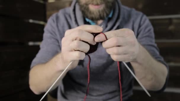 Mãos close-up com agulhas de tricô, homem barbudo tentando tricotar — Vídeo de Stock