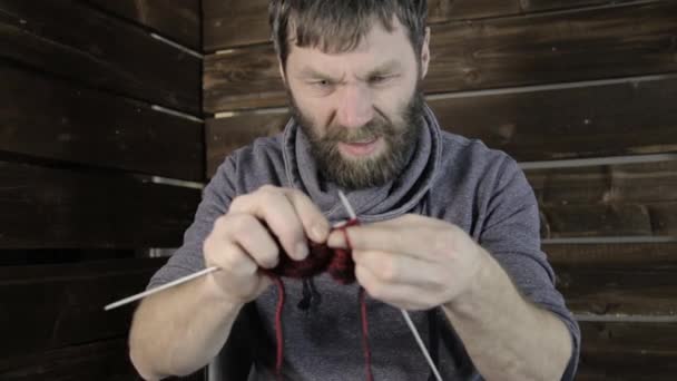 Close-up hands with knitting needles, bearded man trying to knit — Stock Video